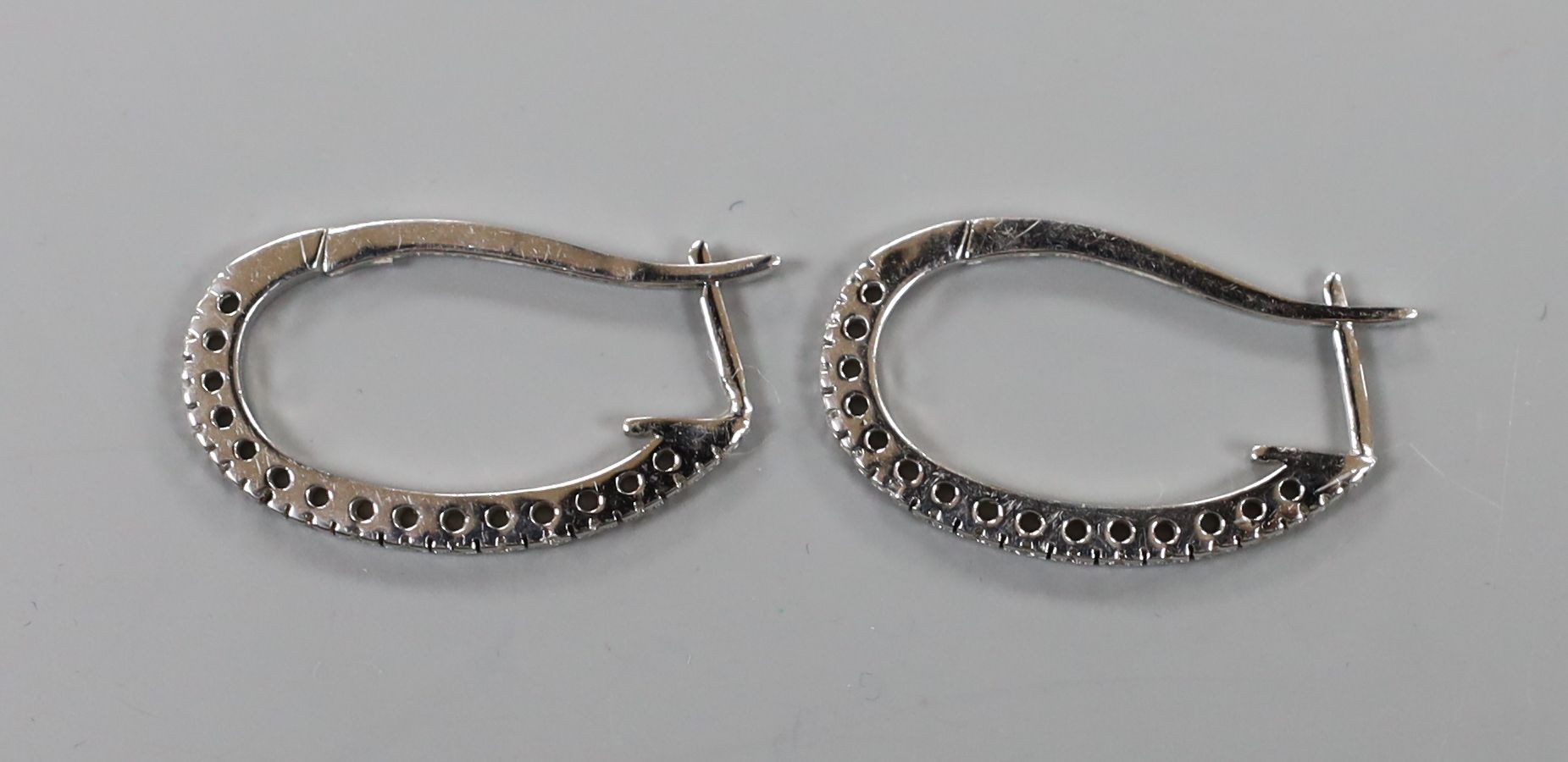 A pair of modern white metal and diamond chip set half hoop earrings, 27mm,gross weight 5.9 grams.